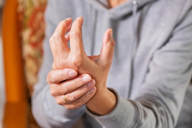 Senior woman suffering from hand and finger joint pain inflammation